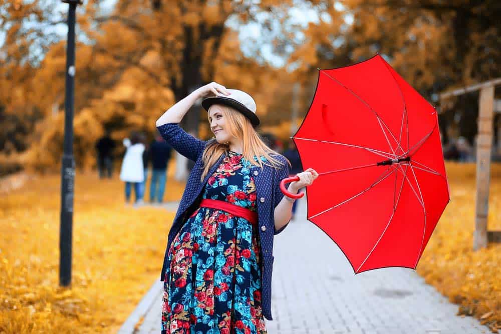 Buntes Kleid für Regentage mit rotem Regenschirm (de.depositphotos.com)